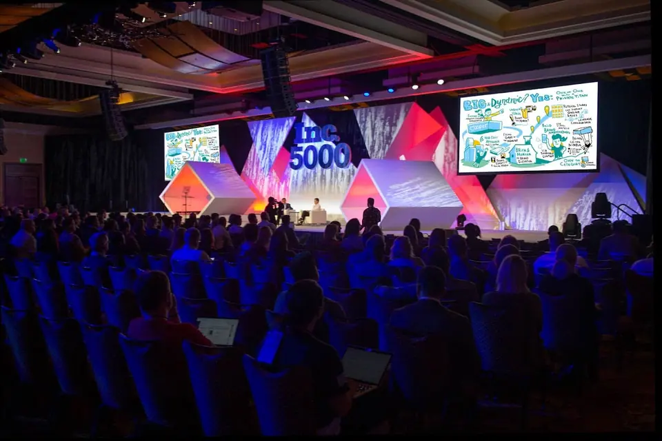 Large-scale presentation drawing shown on stage at a conference event.