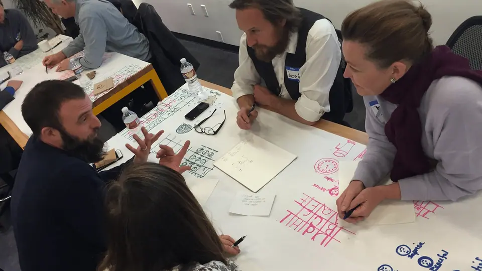 Group of people discussing how visual facilitation solves problems experienced from  brainstorming.