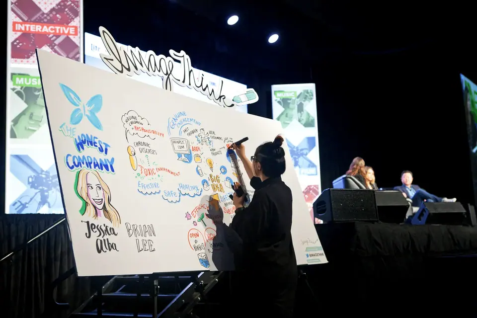 A visual facilitation expert working on a graphic during a nonprofit event.