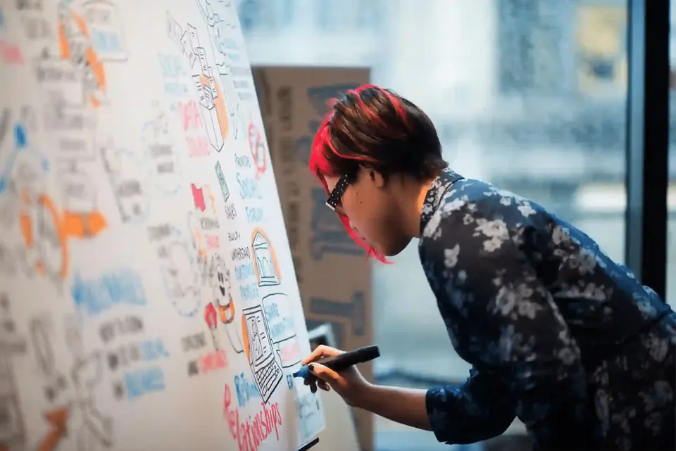 Live scribe capturing sales kickoff ideas, themes, and strategy on a large illustrated board.