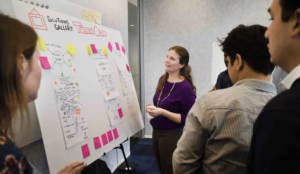 Facilitator reviewing a visual frameworks wall with group.